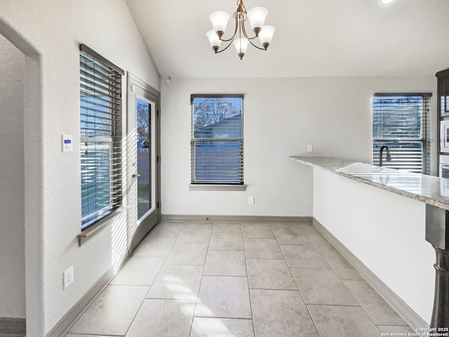 unfurnished dining area with sink, light tile patterned floors, an inviting chandelier, and vaulted ceiling