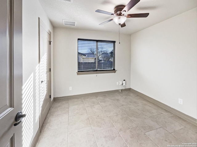 tiled empty room with a textured ceiling and ceiling fan