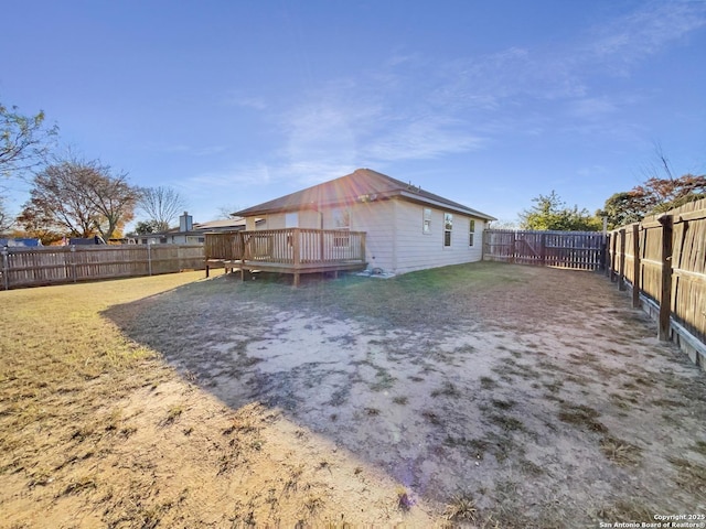 back of house with a deck and a yard