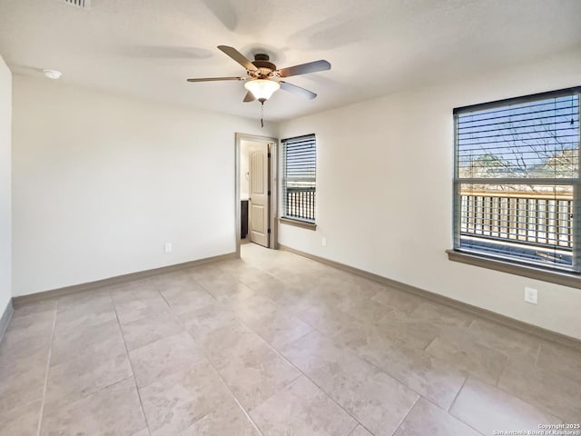 spare room with ceiling fan and light tile patterned floors