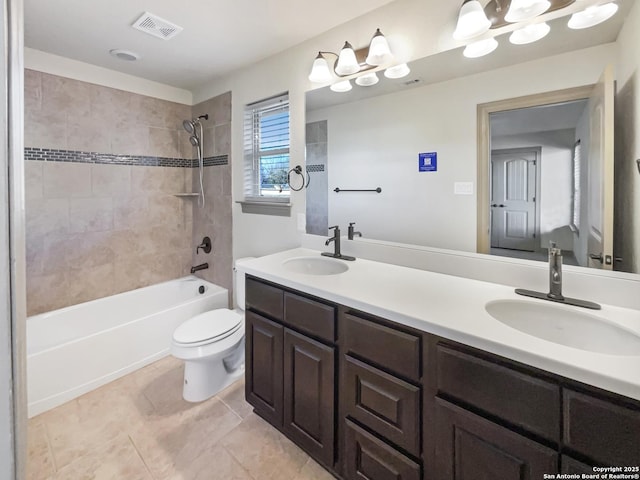 full bathroom featuring toilet, vanity, tile patterned flooring, and tiled shower / bath