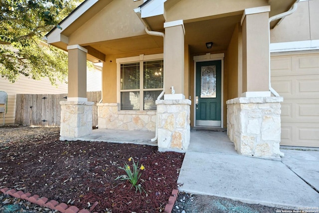 doorway to property with covered porch and a garage