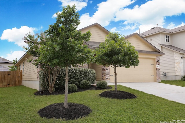 view of property hidden behind natural elements with a front yard and a garage