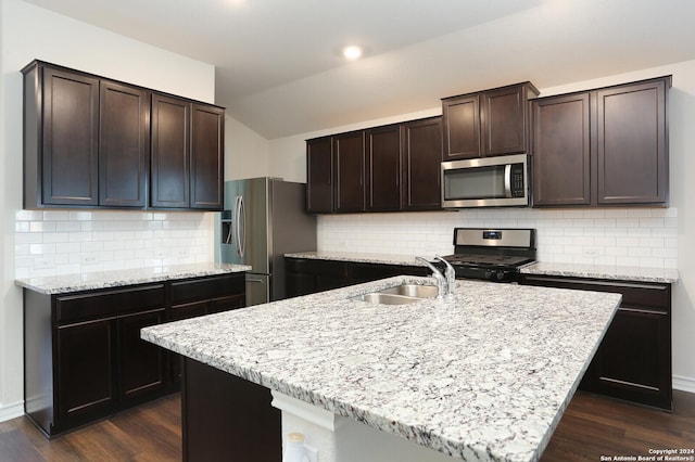 kitchen with backsplash, sink, a center island with sink, and appliances with stainless steel finishes