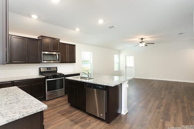 kitchen featuring ceiling fan, sink, lofted ceiling, a kitchen island with sink, and appliances with stainless steel finishes