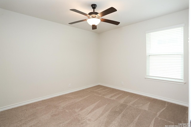 spare room featuring ceiling fan, carpet floors, and a wealth of natural light