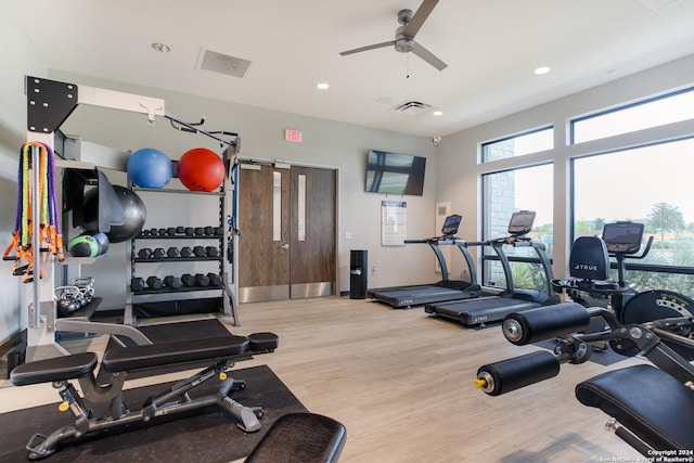 workout area with ceiling fan and light wood-type flooring