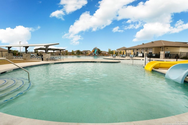 view of swimming pool featuring a pergola, a patio, and a water slide