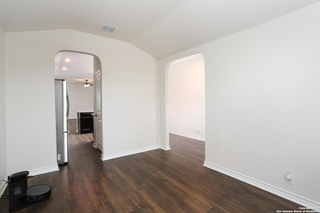 spare room featuring lofted ceiling and dark wood-type flooring