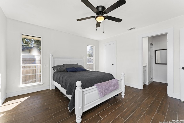 bedroom with connected bathroom, multiple windows, and ceiling fan