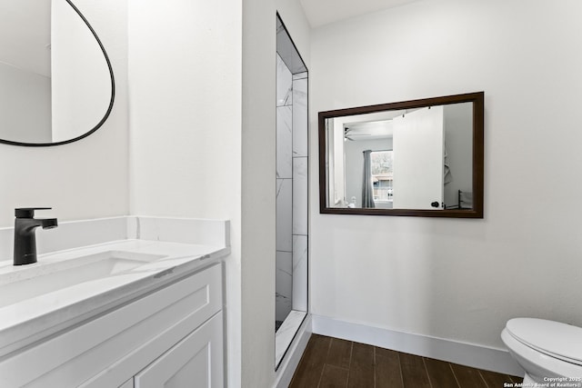 bathroom with a shower, vanity, toilet, and ceiling fan