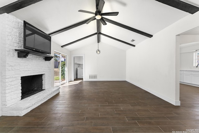 unfurnished living room with vaulted ceiling with beams, washer / clothes dryer, a stone fireplace, and ceiling fan