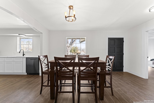 dining room featuring a chandelier, dark hardwood / wood-style floors, plenty of natural light, and sink