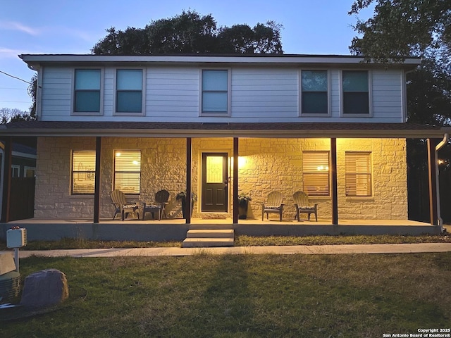 view of front property featuring a porch and a yard