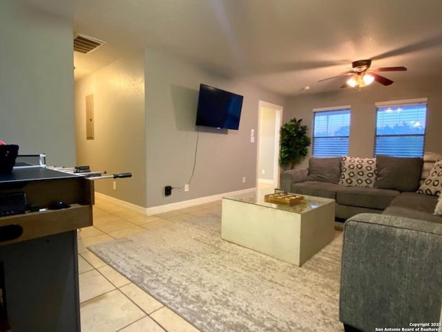 tiled living room with ceiling fan and electric panel