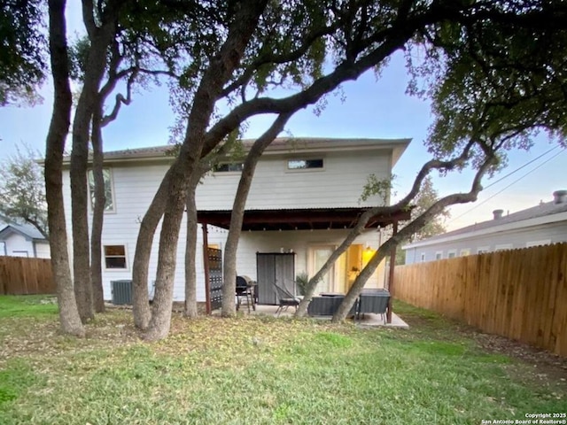 back of property featuring central AC and a yard