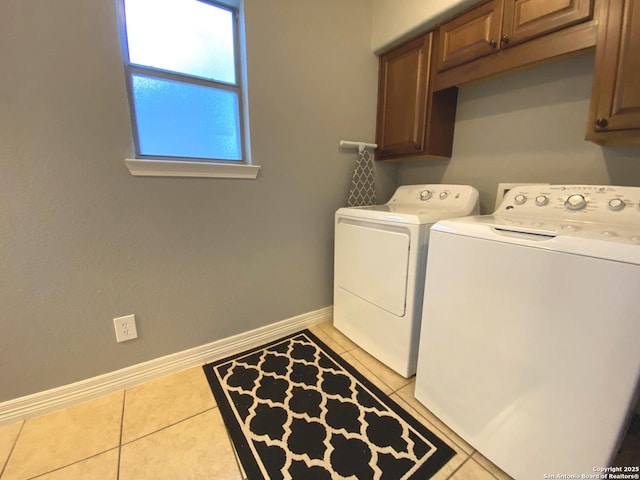 laundry area featuring cabinets, washing machine and clothes dryer, and light tile patterned floors