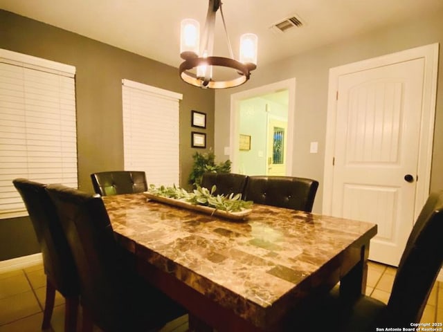 dining room featuring a notable chandelier and light tile patterned floors