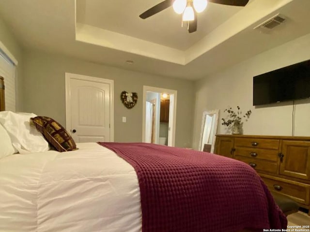 bedroom featuring ceiling fan and a raised ceiling