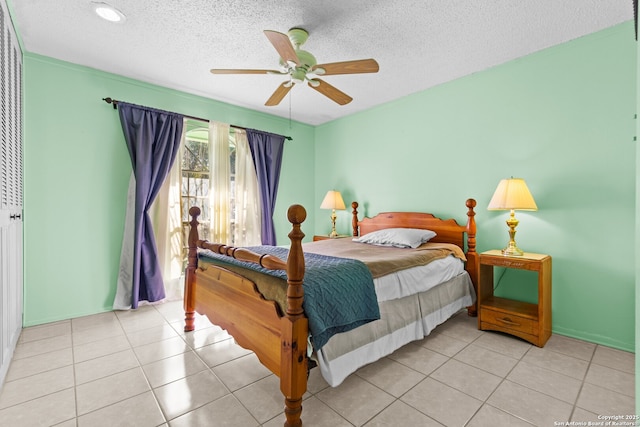 tiled bedroom with a textured ceiling and ceiling fan