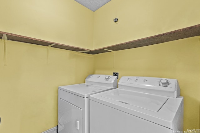 laundry room with washing machine and dryer and a textured ceiling