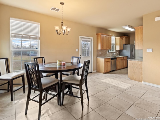 tiled dining area with sink and a notable chandelier