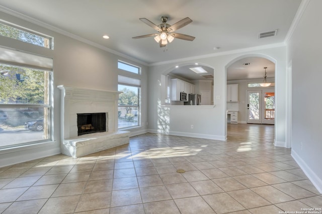 unfurnished living room featuring light tile patterned floors, crown molding, a healthy amount of sunlight, and ceiling fan