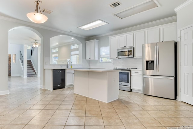 kitchen featuring ceiling fan, white cabinetry, stainless steel appliances, light tile patterned flooring, and decorative light fixtures