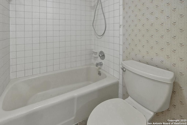 bathroom with tiled shower / bath and toilet