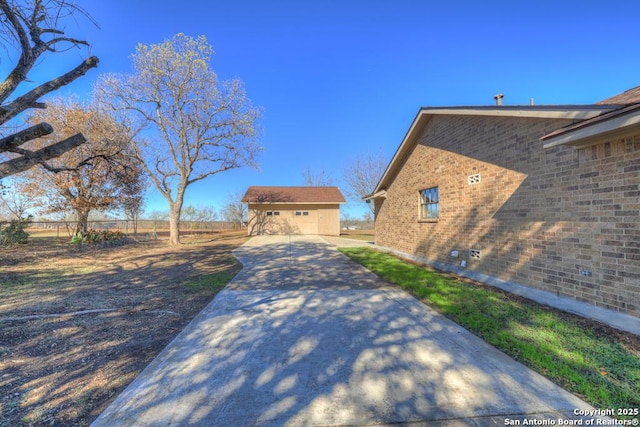 view of property exterior with a patio and an outdoor structure