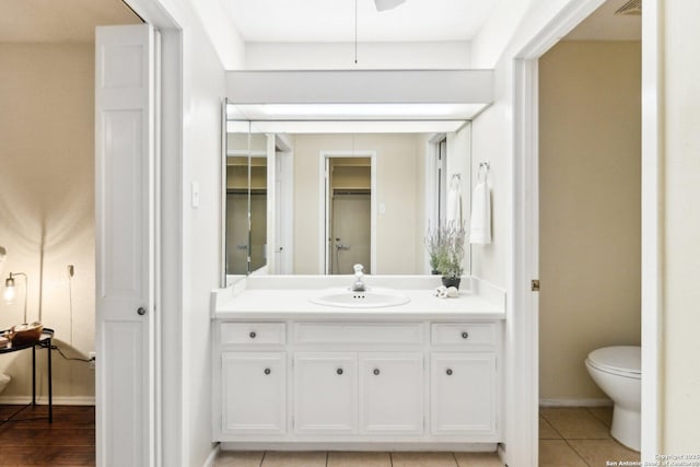 bathroom with toilet, vanity, and tile patterned floors