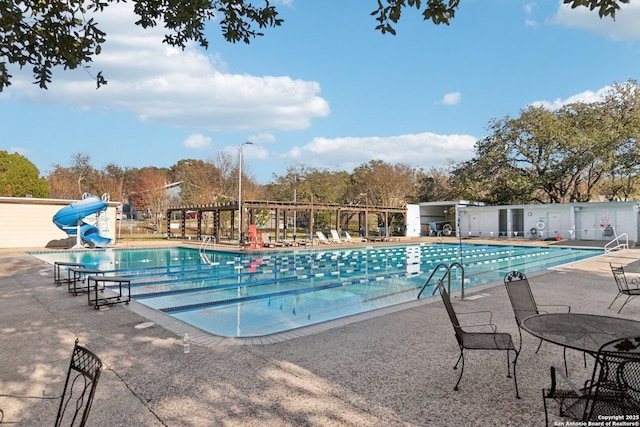 view of swimming pool featuring a water slide and a patio