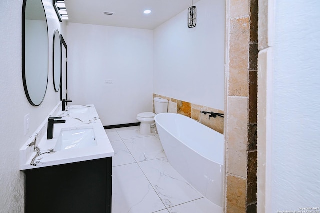 bathroom with toilet, a washtub, and vanity