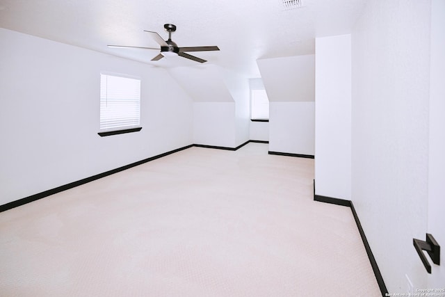 additional living space with ceiling fan, vaulted ceiling, and light carpet