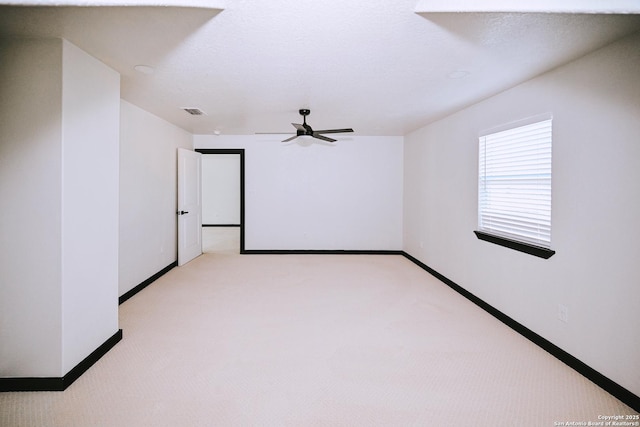 empty room featuring ceiling fan and light colored carpet