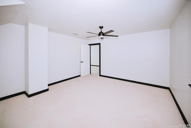 unfurnished room with a textured ceiling, ceiling fan, and light colored carpet