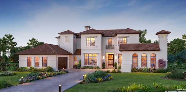 mediterranean / spanish-style house featuring a garage and a front lawn