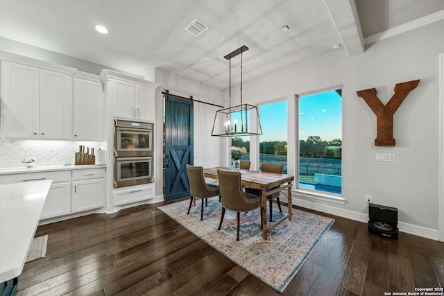 dining area featuring a barn door and dark hardwood / wood-style floors