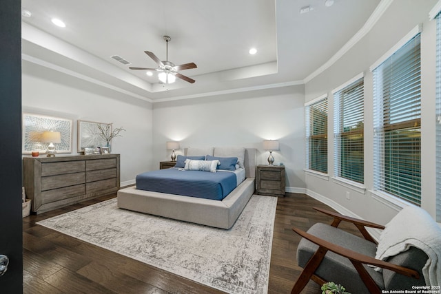 bedroom featuring dark wood-type flooring, a raised ceiling, ceiling fan, and crown molding