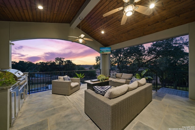 patio terrace at dusk with ceiling fan and an outdoor living space