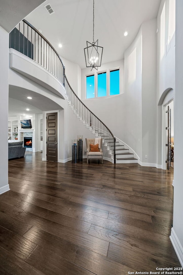 entryway with a high ceiling, dark hardwood / wood-style flooring, and a chandelier