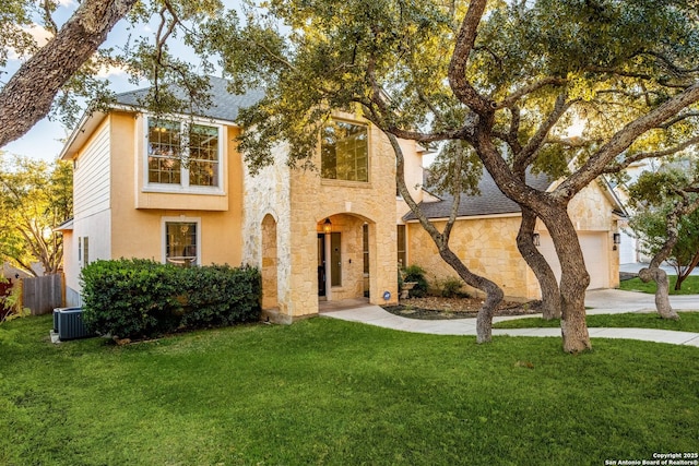 view of front of home featuring a garage, cooling unit, and a front lawn