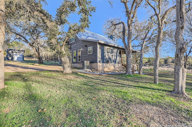 view of side of home featuring central AC unit and a yard