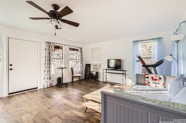 bedroom featuring ceiling fan, a wall mounted AC, and wood-type flooring