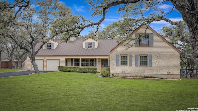 cape cod house featuring a garage and a front lawn