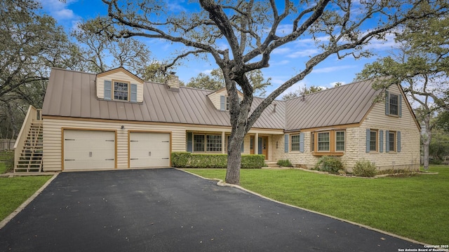 cape cod house featuring a garage and a front yard