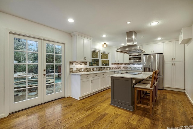 kitchen featuring white cabinetry, stainless steel fridge, a center island, and island exhaust hood