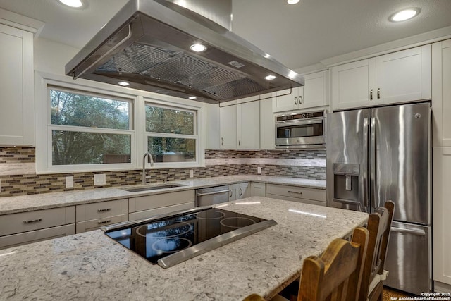 kitchen featuring sink, light stone countertops, appliances with stainless steel finishes, and island exhaust hood