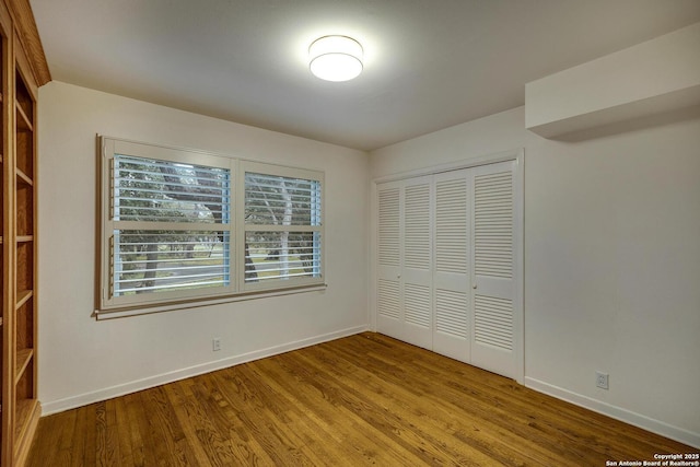 unfurnished bedroom with hardwood / wood-style flooring and a closet