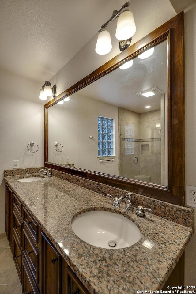 bathroom featuring tile patterned flooring, vanity, and a shower with shower door